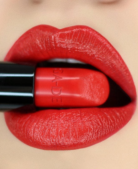 שפתיים מצופות באודם אדום נוגסות בשפתון אדום.